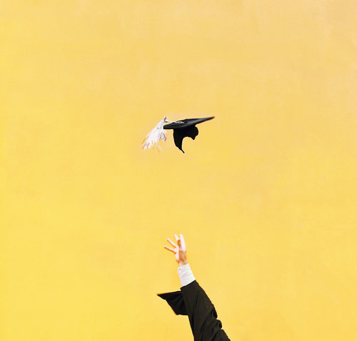 Photo of a college graduation cap being thrown into the air